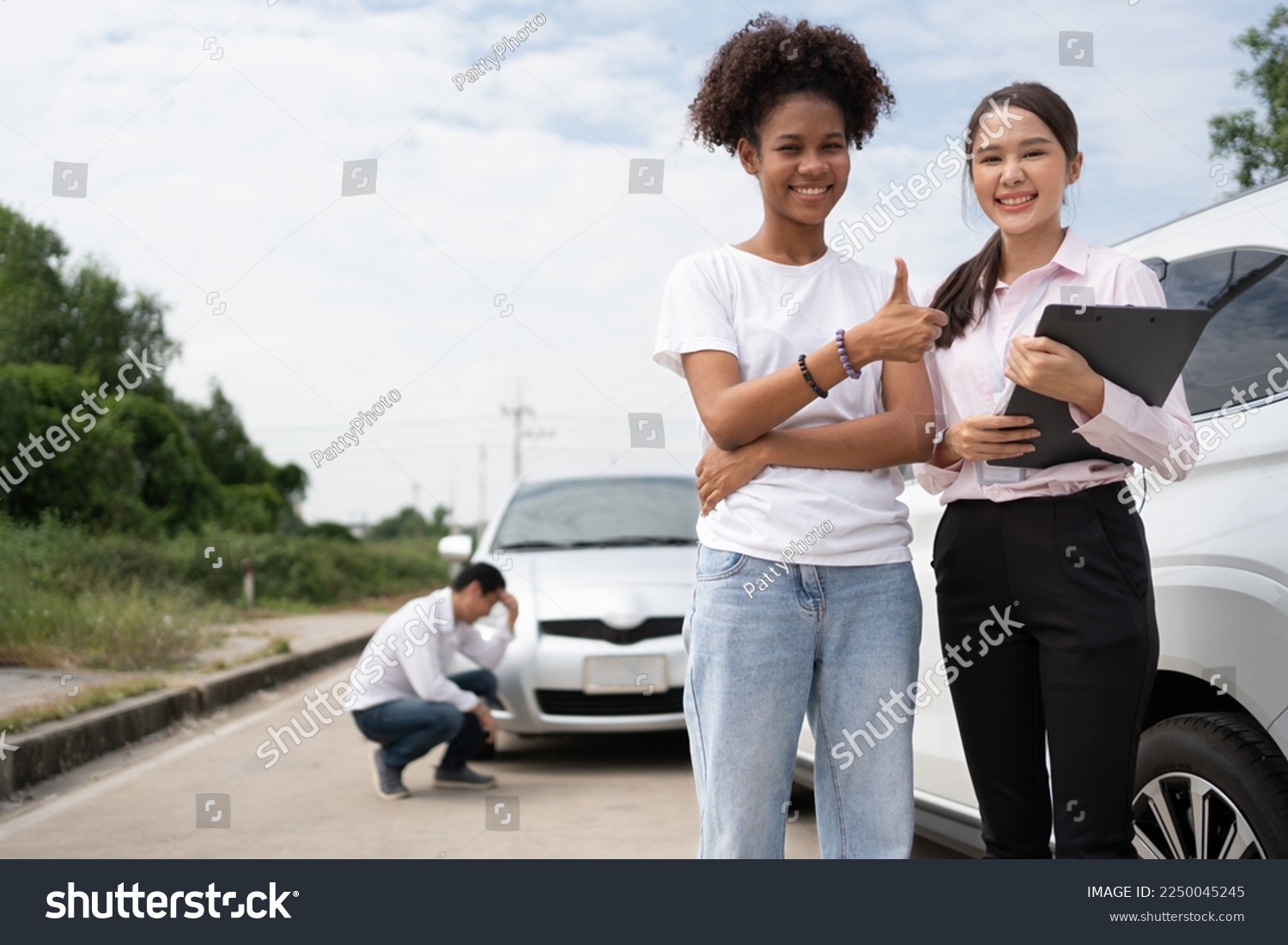 Women drivers Talk to Insurance Agent for examining damaged car and customer checks on the report claim form after an accident. Concept of insurance, advice auto repair shop and car traffic accidents. #2250045245