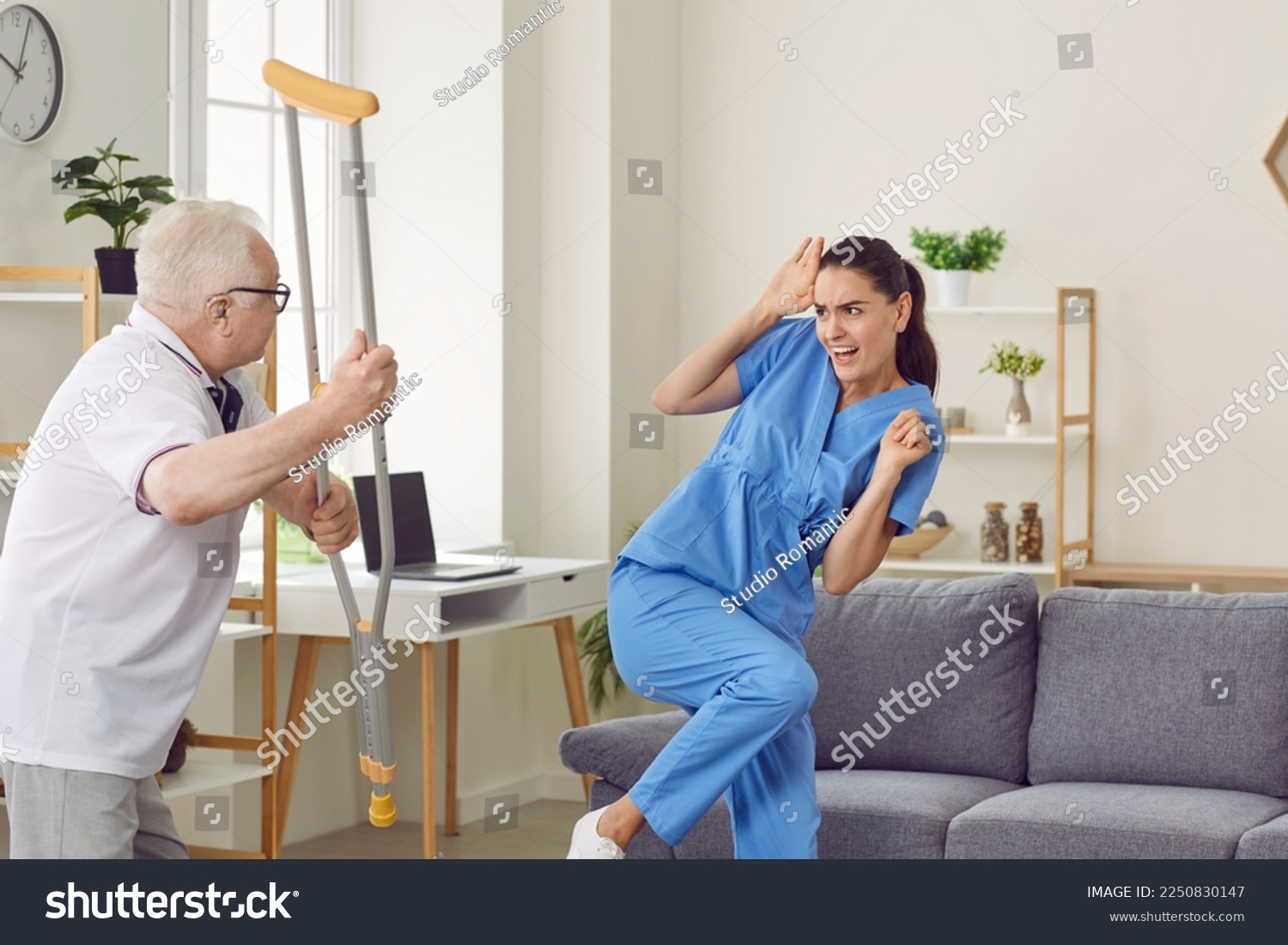 Angry aggressive elderly man threatening to his caregiver woman. Elderly patient suffering from mental disability threatening with crutch to frightened nurse. Professional medical help and support #2250830147
