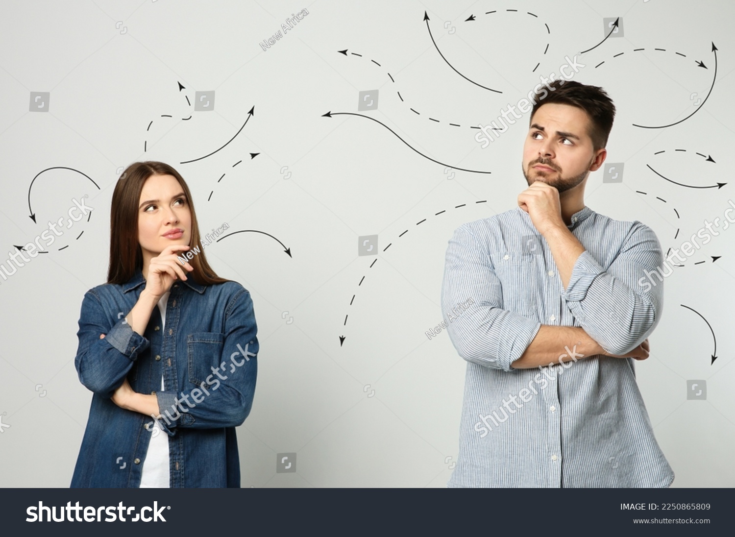 Choice in profession or other areas of life, concept. Making decision, thoughtful young man and woman surrounded by drawn arrows on light background #2250865809
