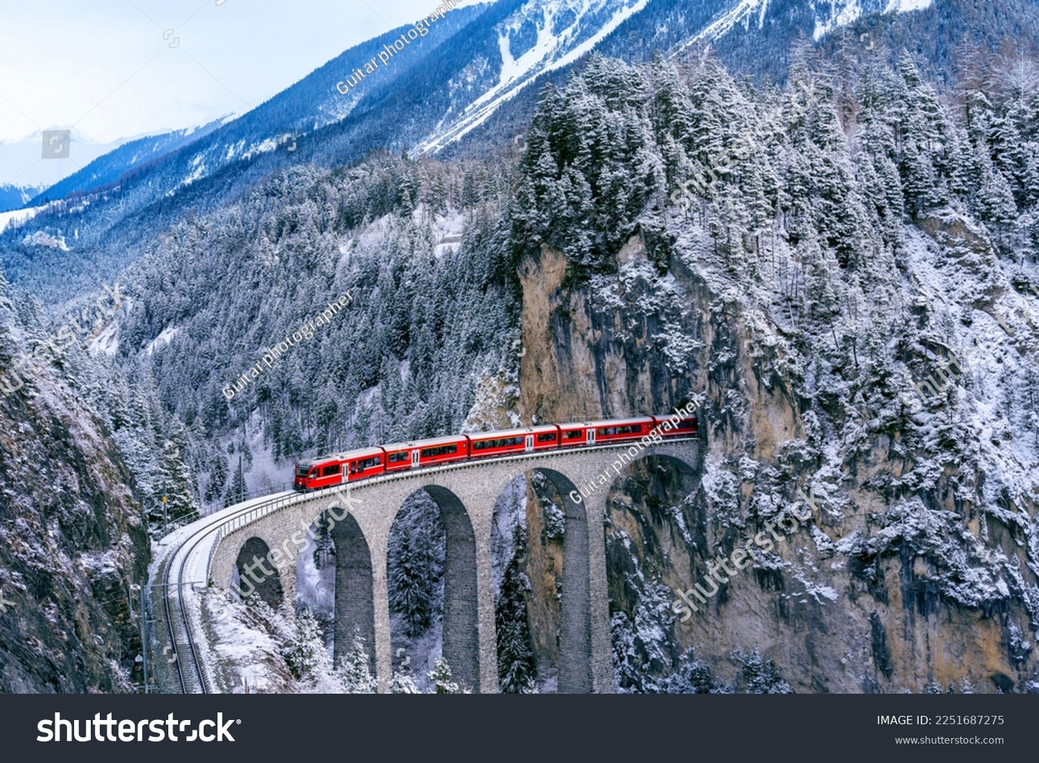 Aerial view of Train passing through famous mountain in Filisur, Switzerland. Landwasser Viaduct world heritage with train express in Swiss Alps snow winter scenery.  #2251687275