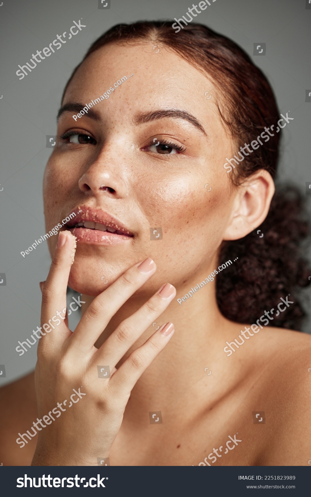 Face, sugar scrub and lips of woman in studio isolated on a gray background. Portrait, cosmetics and skincare of female model with lip dermatology product for exfoliation, cleaning and healthy skin. #2251823989