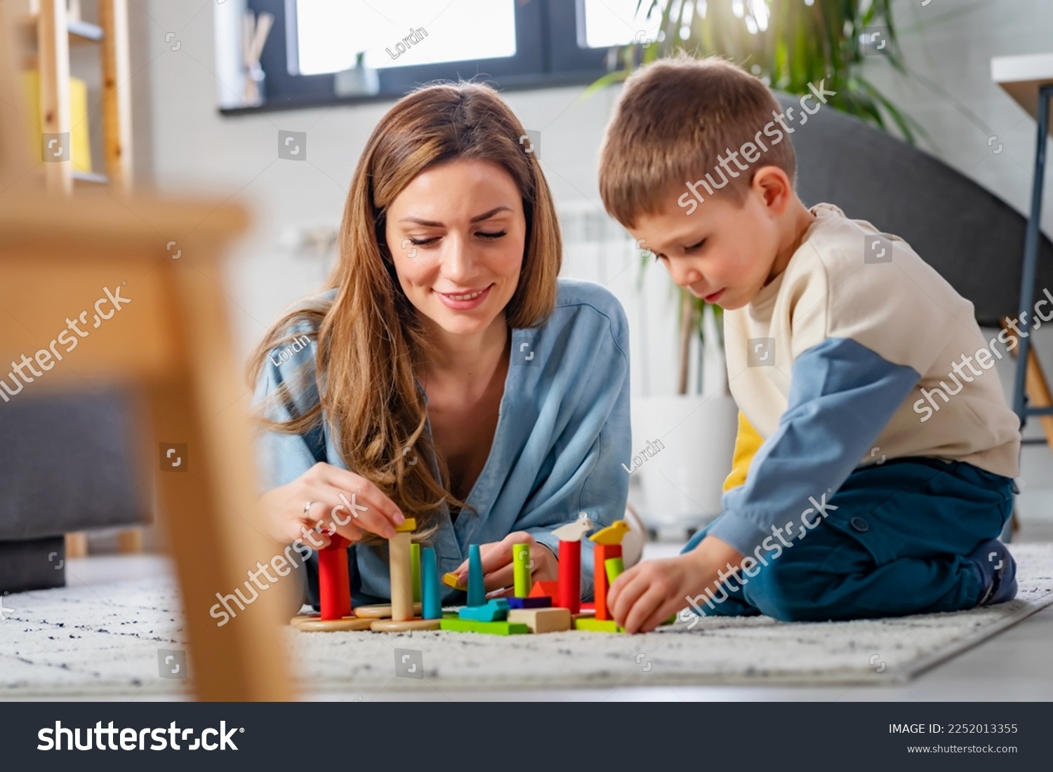 Mother and her son playing on the floor with colorful didactic toys at home. Early education and development  #2252013355