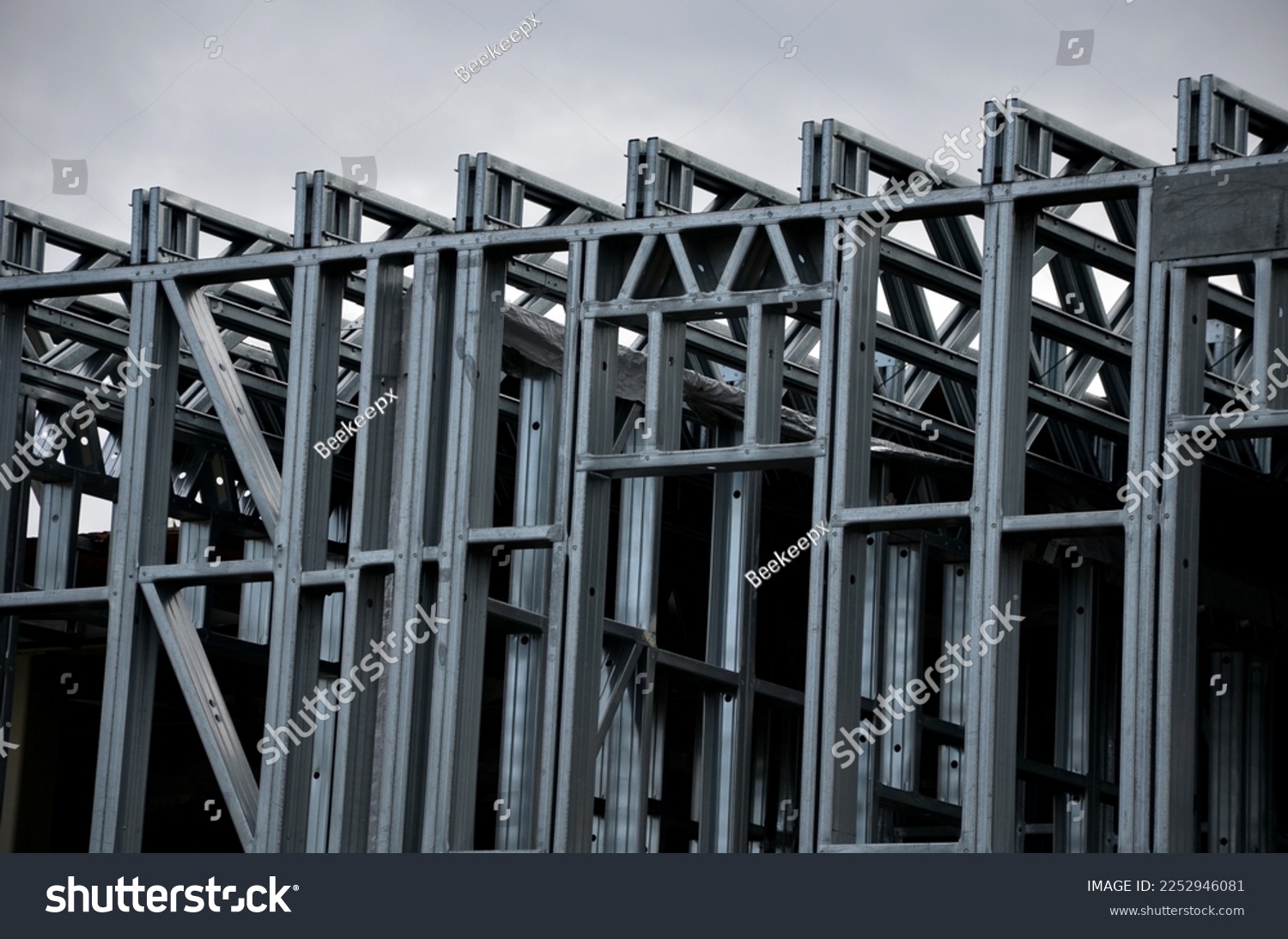 Building construction from metal trusses. lattice structure of the frame of an industrial building. A large thick tangle on the ceiling of a building under construction. shiny metal profiles steel #2252946081