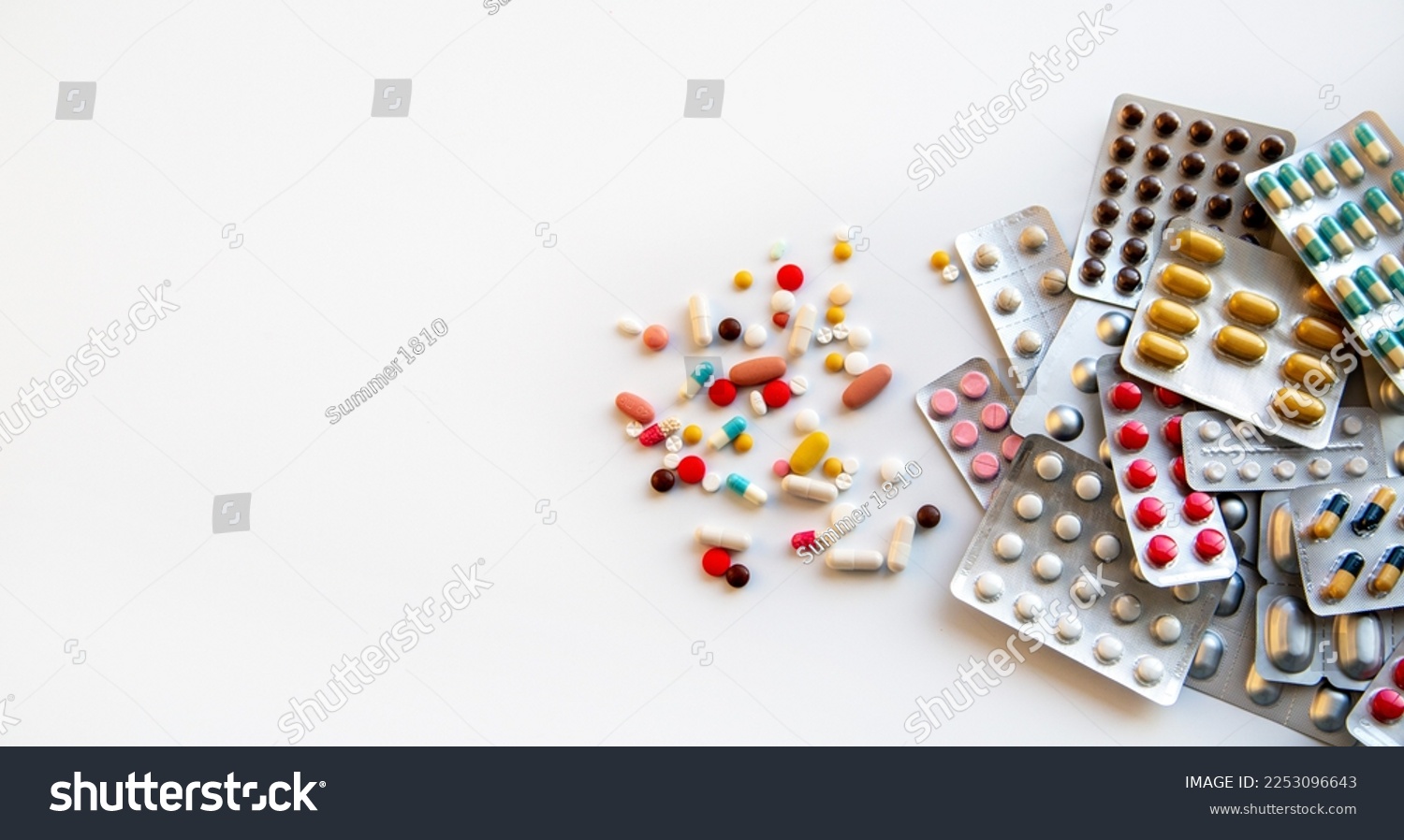 Blisters with various pills and capsules on a white background with copy space. Medicine, pharmaceuticals, treatment and prevention of diseases. #2253096643