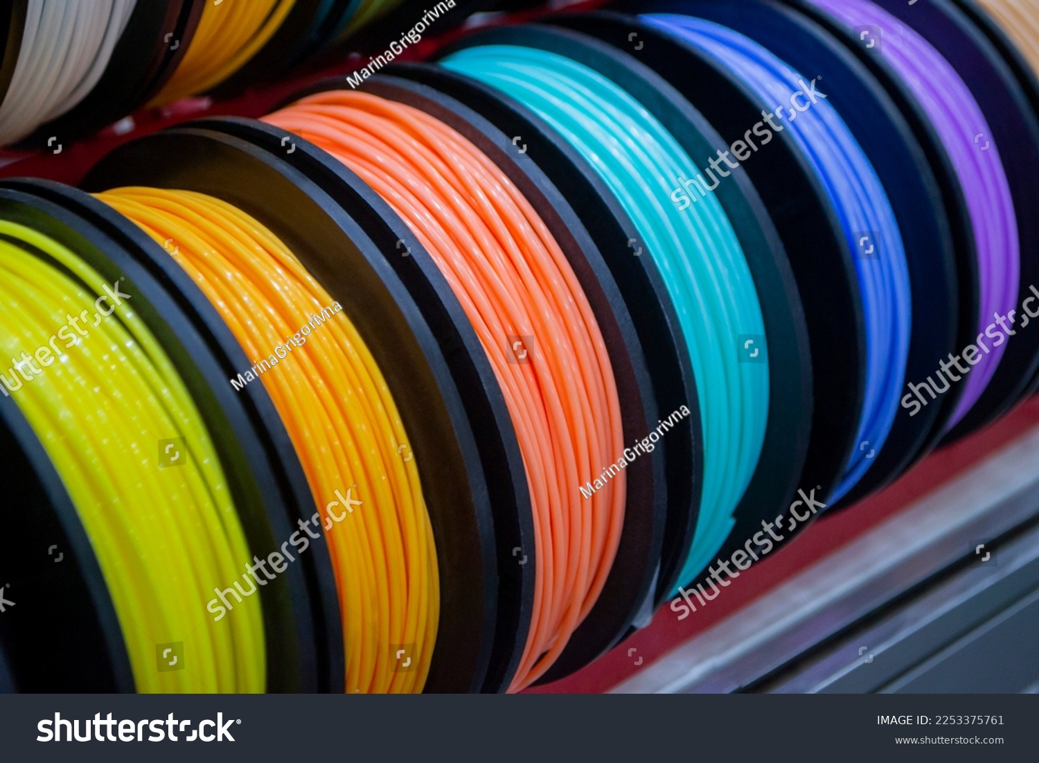Many multi-colored spools of thread of filament for printing 3d printer. Material coils for printing 3D printer. Spools of 3D printing motley different colors filament. ABS wire plastic for 3d printer #2253375761