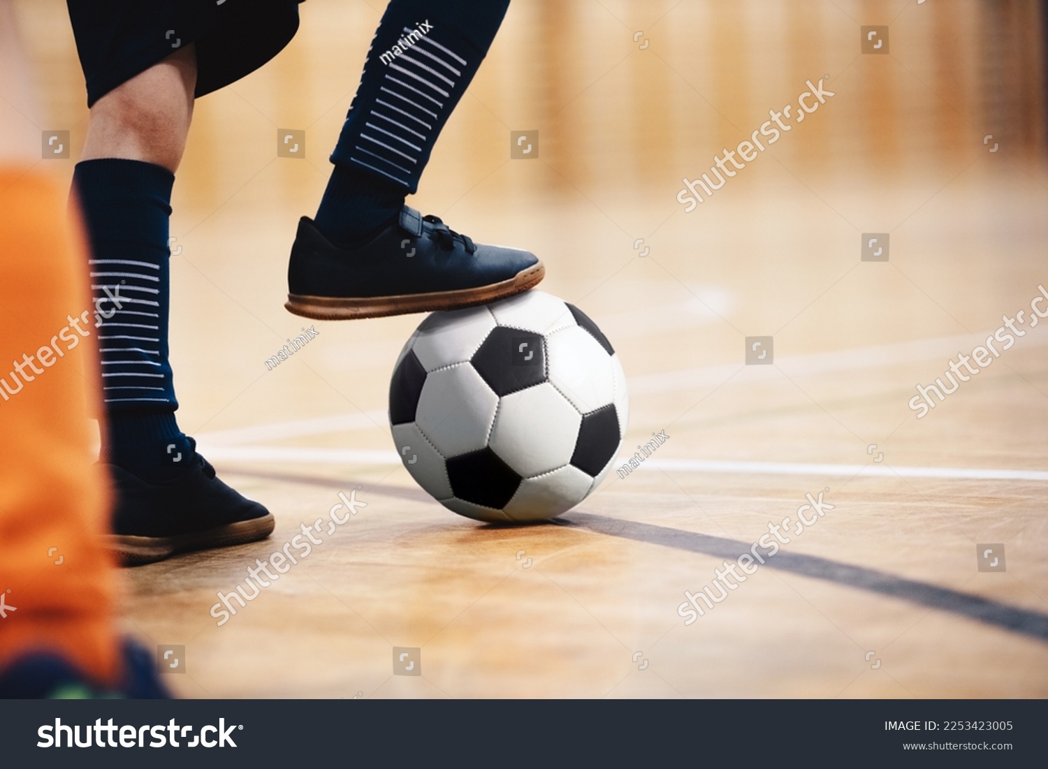 Football futsal player, ball, futsal floor. Indoor soccer sports hall. School boys on indoor football training session #2253423005