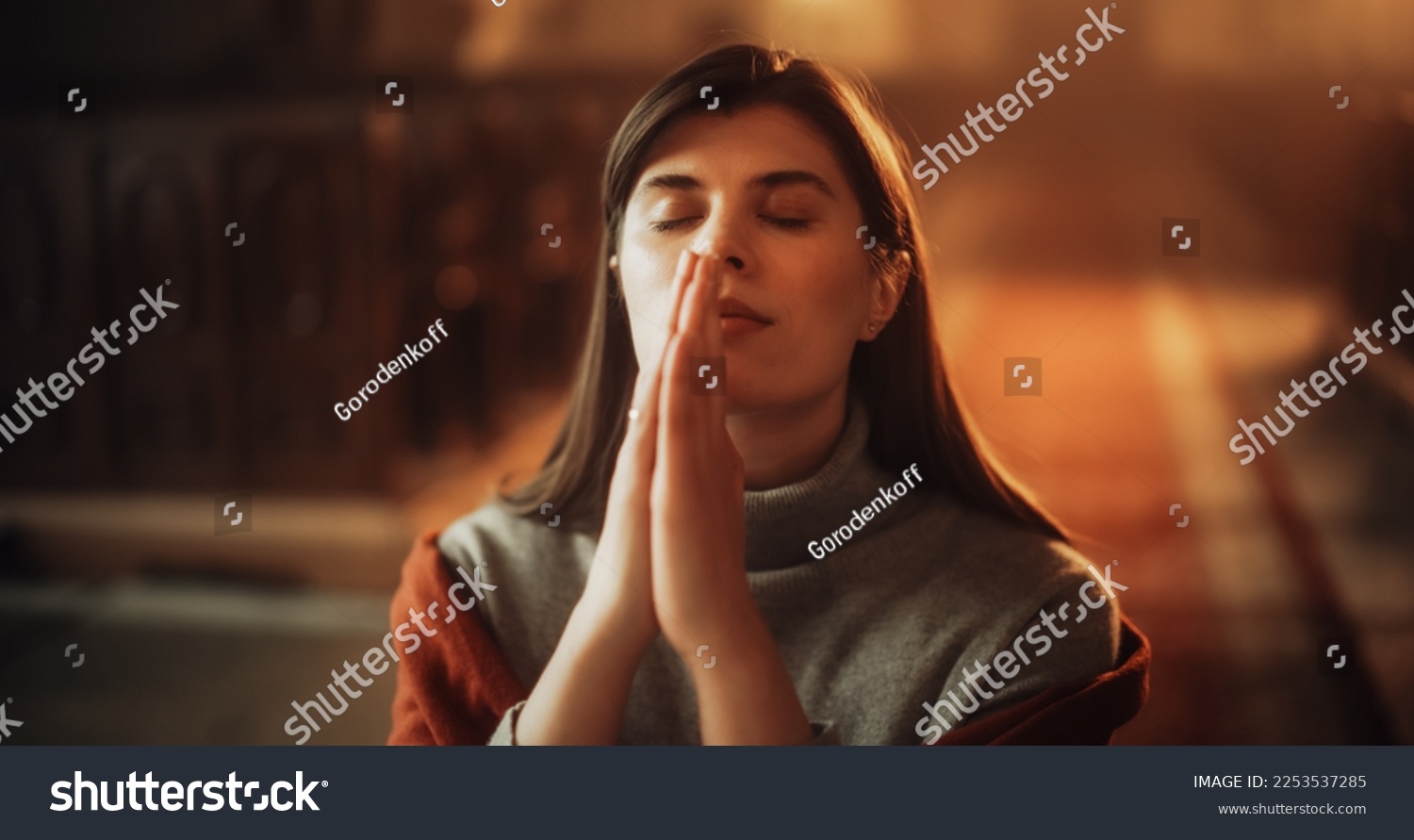 Devout Praying Christian Woman, Bowing In Humble Reverence To God. With Hands Folded She Looks Upwards Before Closing Eyes. Seeking Guidance and Strength to Live a Life in Accordance with The Bible #2253537285