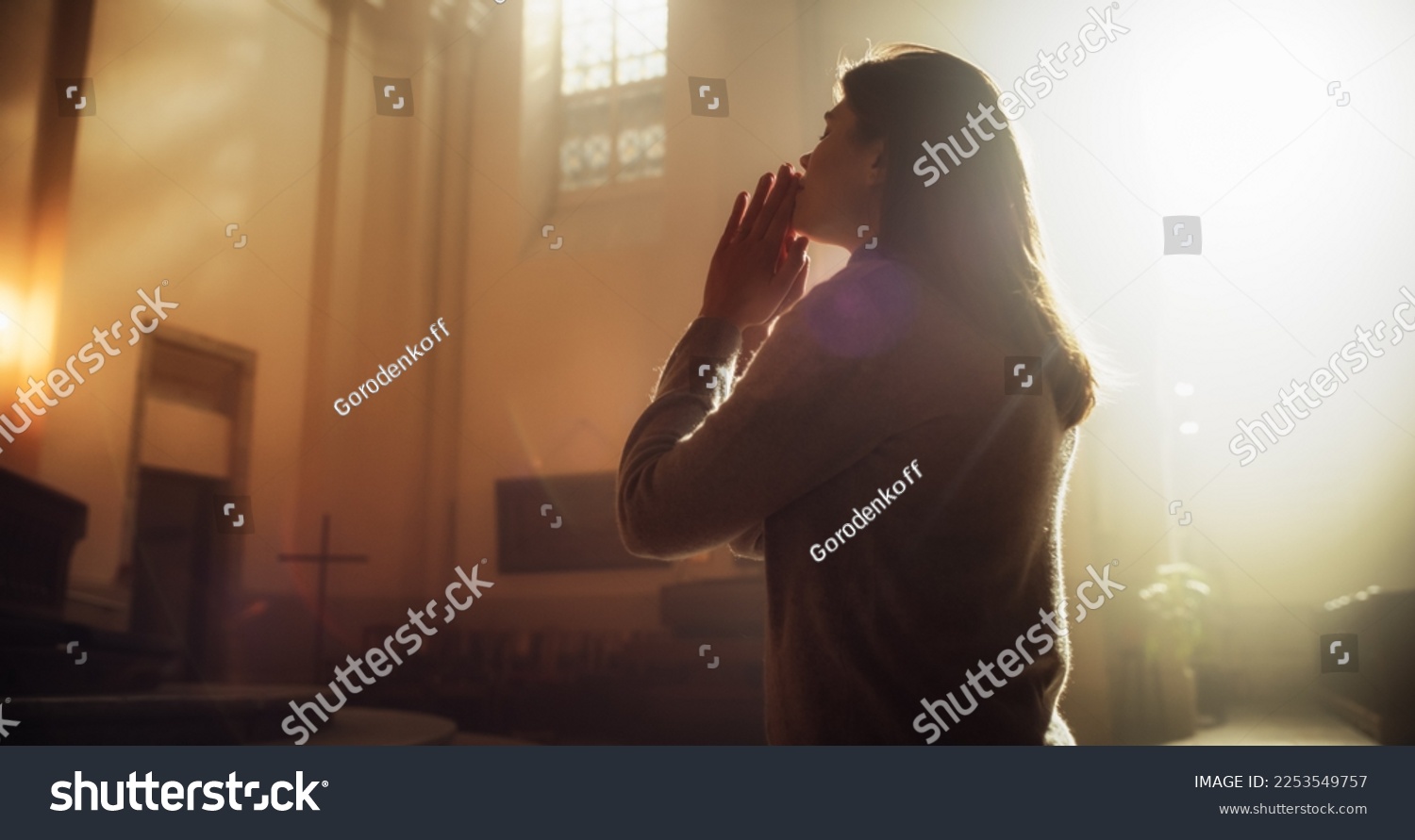 Side View: Christian Woman Getting on her Knees in Front of Altar and Starting to Pray in Church. Devoted Parishioner Seeks Guidance From Faith and Spirituality. Religious Believer in Power of God #2253549757