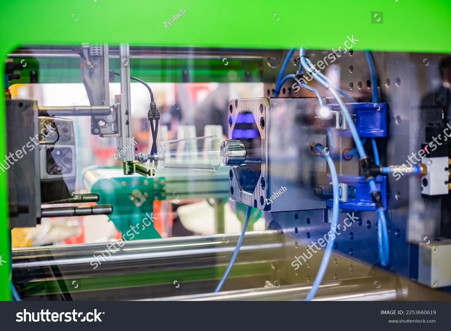 Automatic injection molding machine making disposable plastic cup at exhibition, trade show. Manufacturing, production, technology concept #2253660619