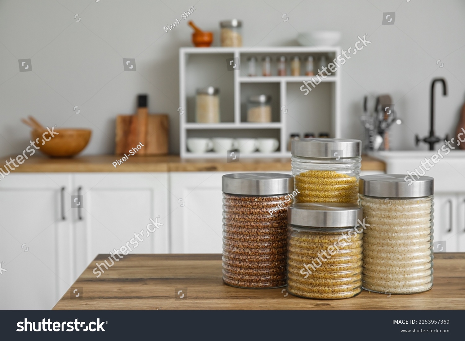 Jars with cereals on wooden table in kitchen #2253957369