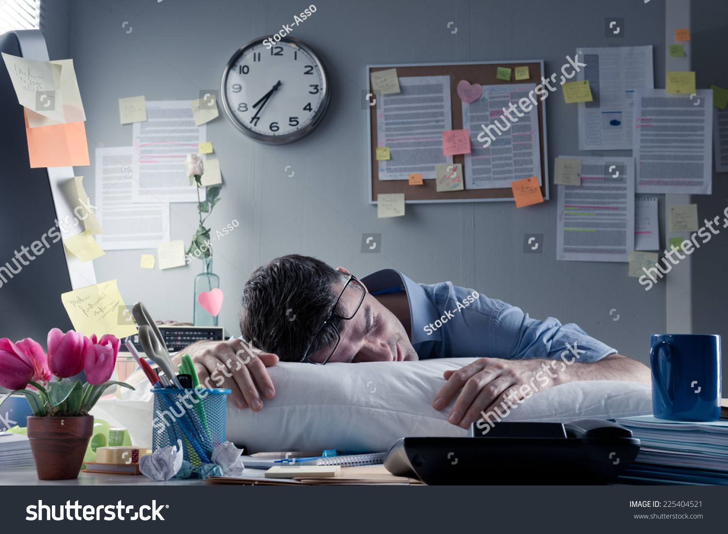 Exhausted businessman sleeping at workplace with a pillow on his desk. #225404521