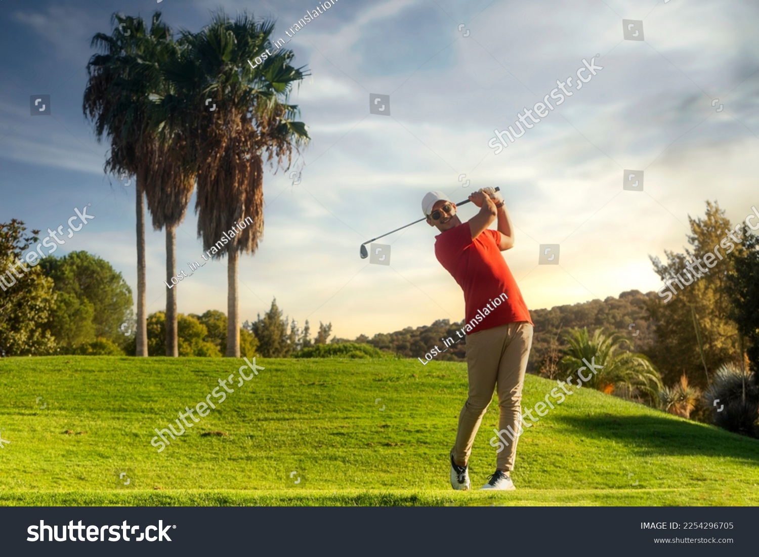 golf shot man. professional golf swing. Golf player teeing off. Front view of golfer finishing swing with a smile. Full length of golfer playing on the course. Golfer hitting golf shot with club #2254296705