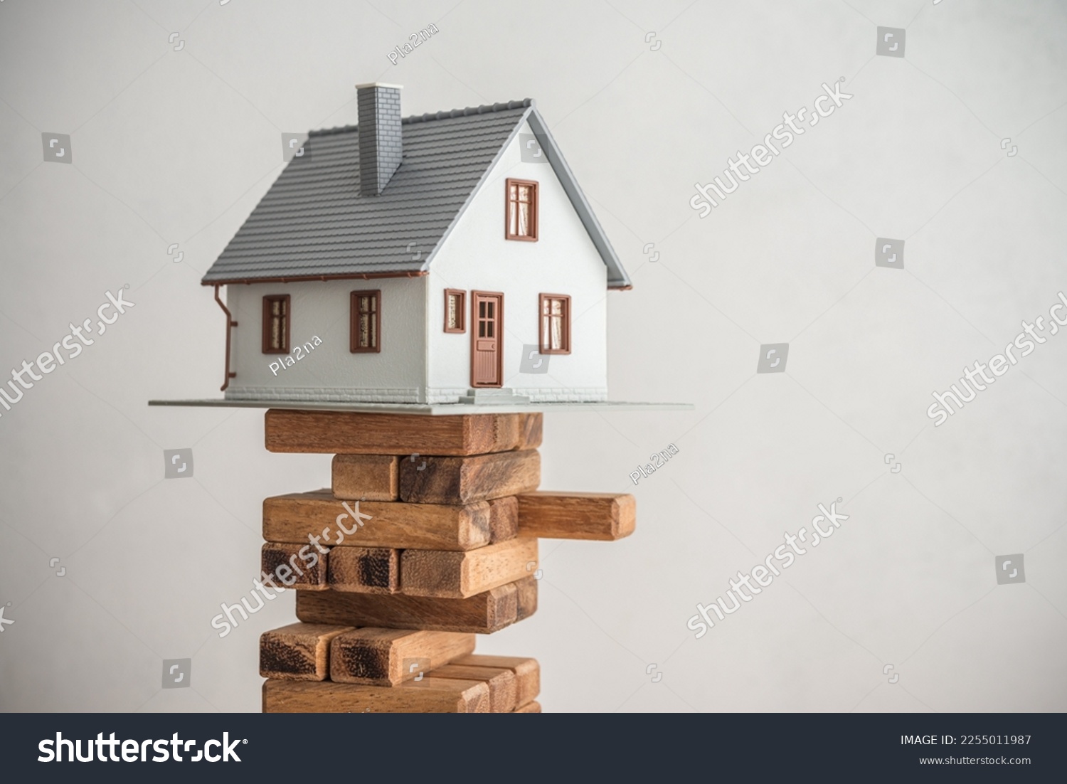 Modern house on wood tower block game white wall background copy space. Mortgage loan for buying home or real estate property, money risk management in financial, foreclosure and bankruptcy  concept. #2255011987