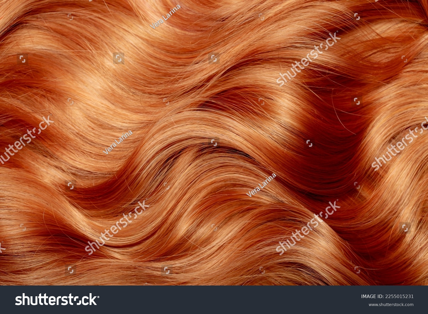 Red hair close-up as a background. Women's long orange hair. Beautifully styled wavy shiny curls. Hair coloring bright shades. Hairdressing procedures, extension. #2255015231