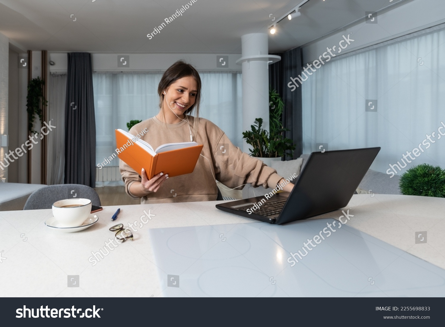 Young business woman attends online retraining course for more opportunities in progress to find a better job watching and listening to a lecture on laptop and taking notes of important informations #2255698833