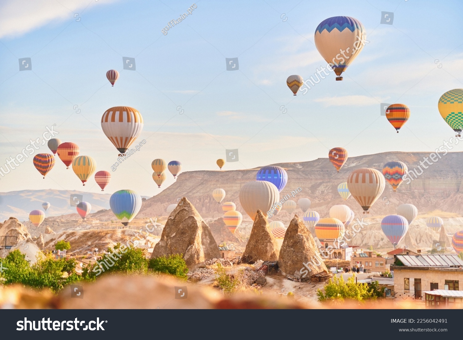 Landscape of fabulous Kapadokya. Colorful flying air balloons in sky at sunrise in Anatolia. Vacations in beautiful destination in Goreme, Turkey  #2256042491