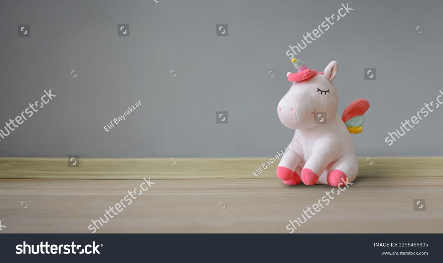 Cute soft unicorn plush toy on the floor. Close up shot, empty space #2256466805