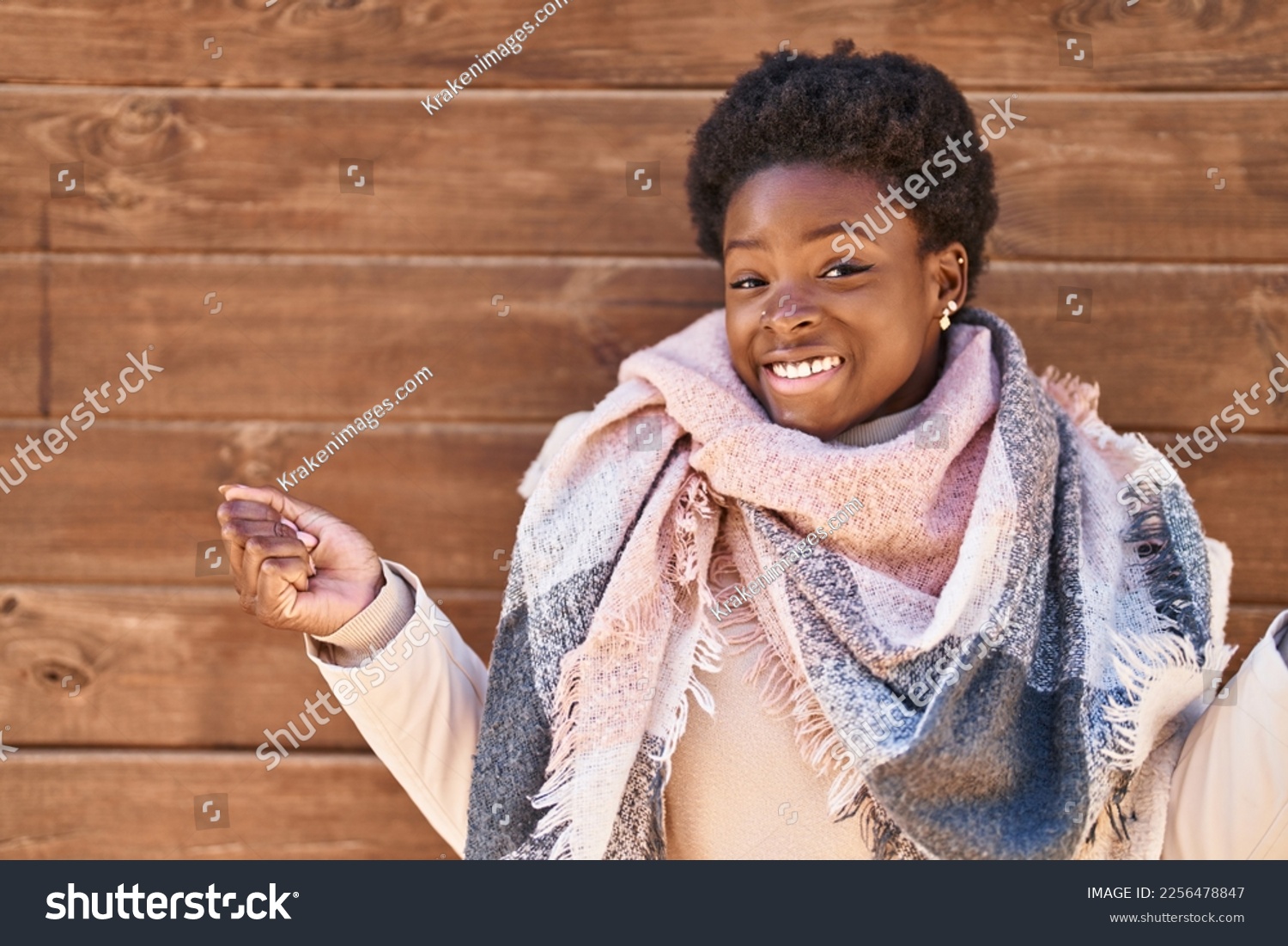 African american woman standing over wood background screaming proud, celebrating victory and success very excited with raised arm  #2256478847