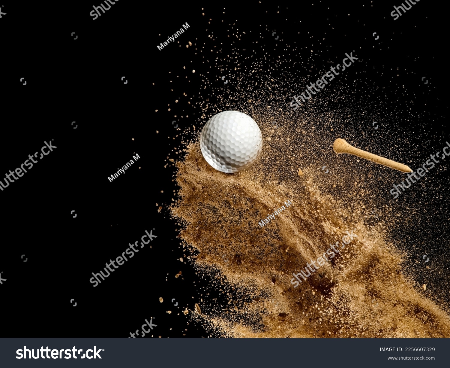 White golf ball in golden dry sand explosion on black background #2256607329