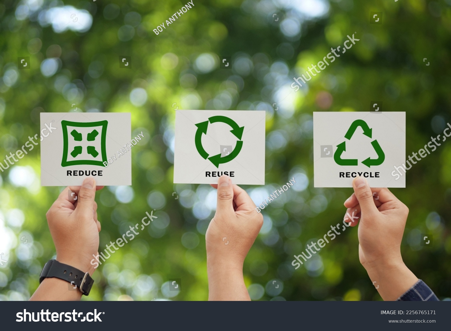 Hand holding reduce, reuse, recycle symbol on green bokeh background. Ecological and save the earth concept. An ecological metaphor for ecological waste management and a sustainable. #2256765171