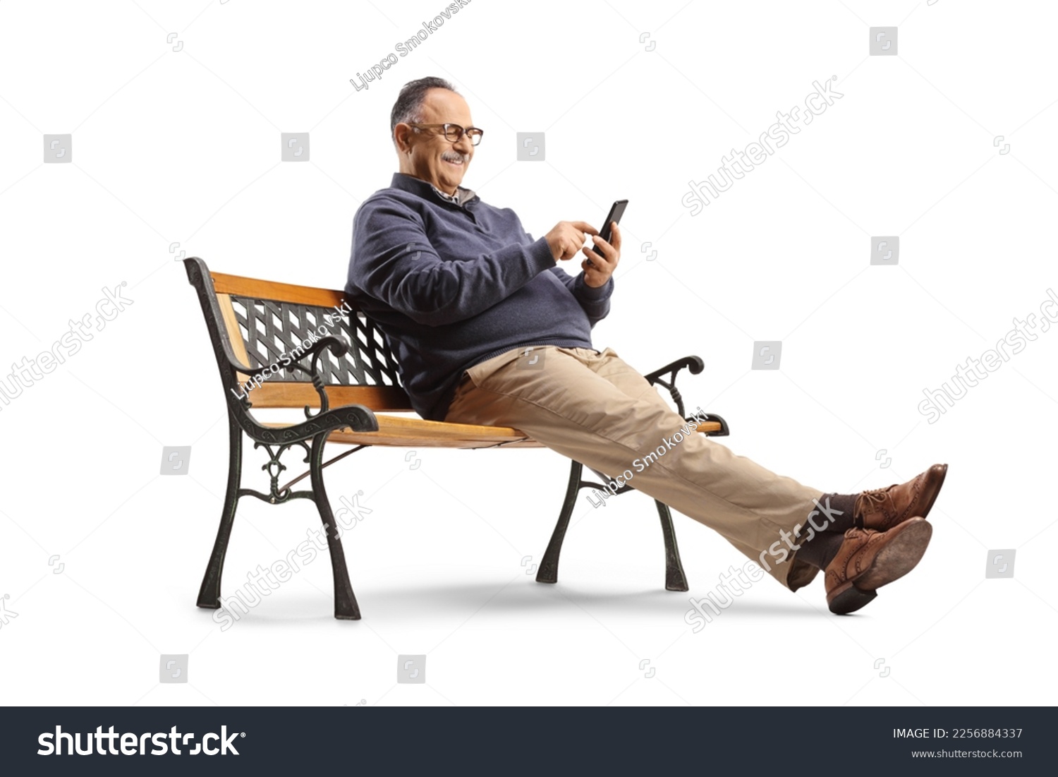 Mature man sitting on a bench and using a smartphone isolated on white background #2256884337
