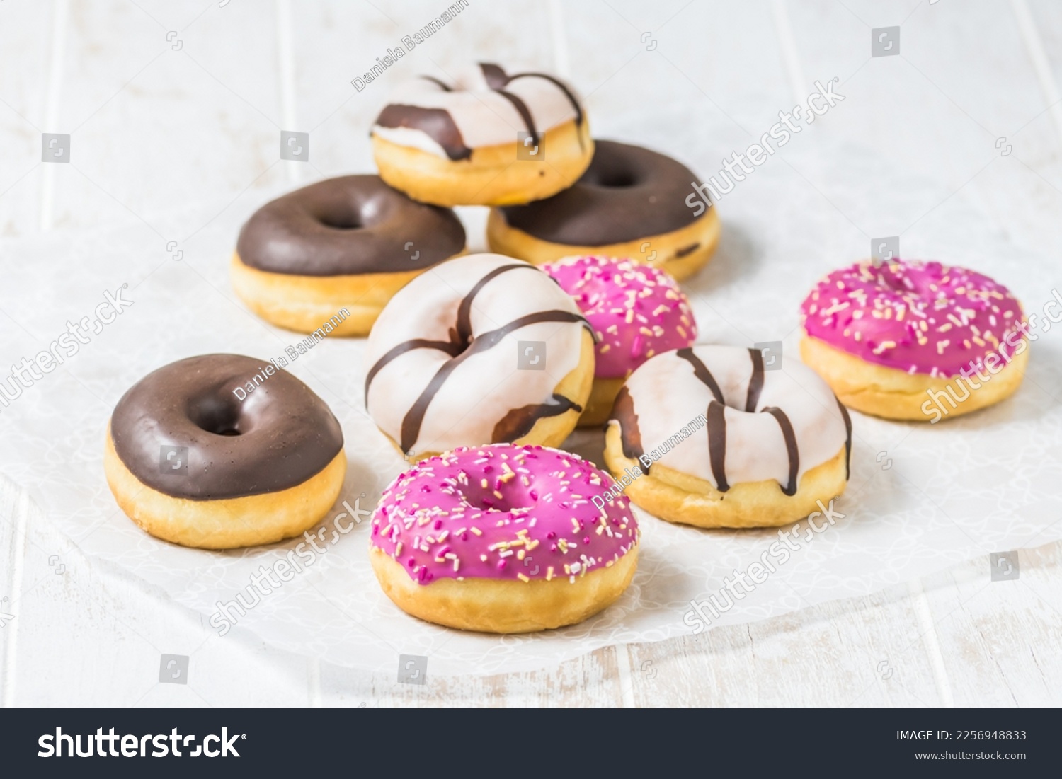 Colorful Donuts, Berliner, Krapfen with sugar icing and chocolate on white wooden background, vertical with copy space #2256948833