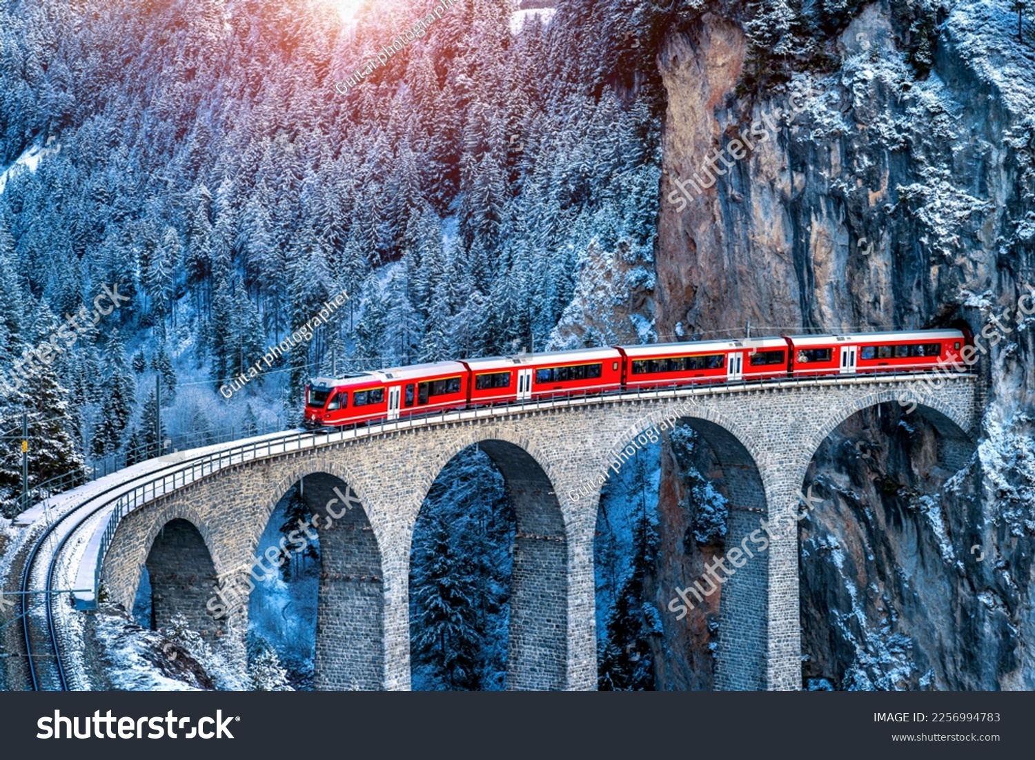 Aerial view of Train passing through famous mountain in Filisur, Switzerland.   train express in Swiss Alps snow winter scenery.  #2256994783