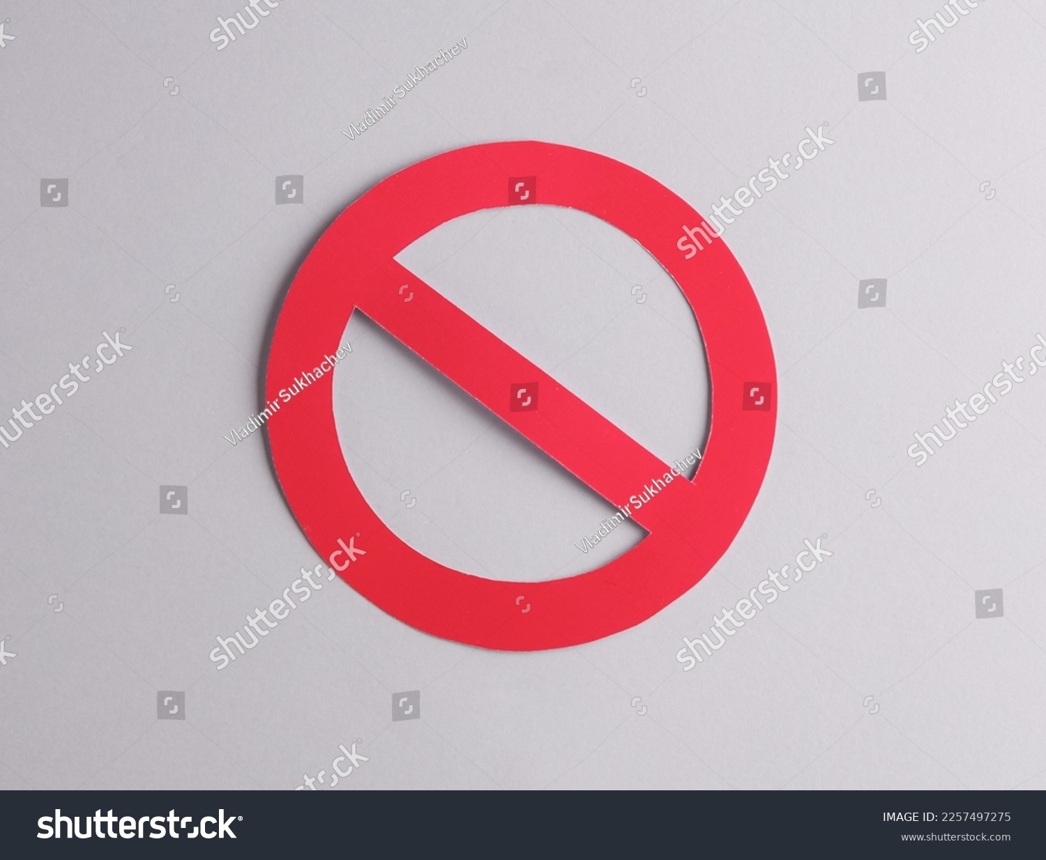 Red prohibition sign cut out of paper on a gray background #2257497275