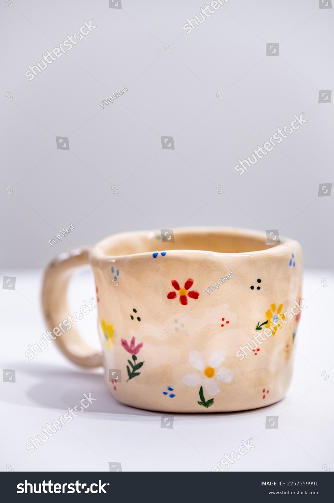 Hand-made ceramic mug with colorful flowers on white background #2257559991