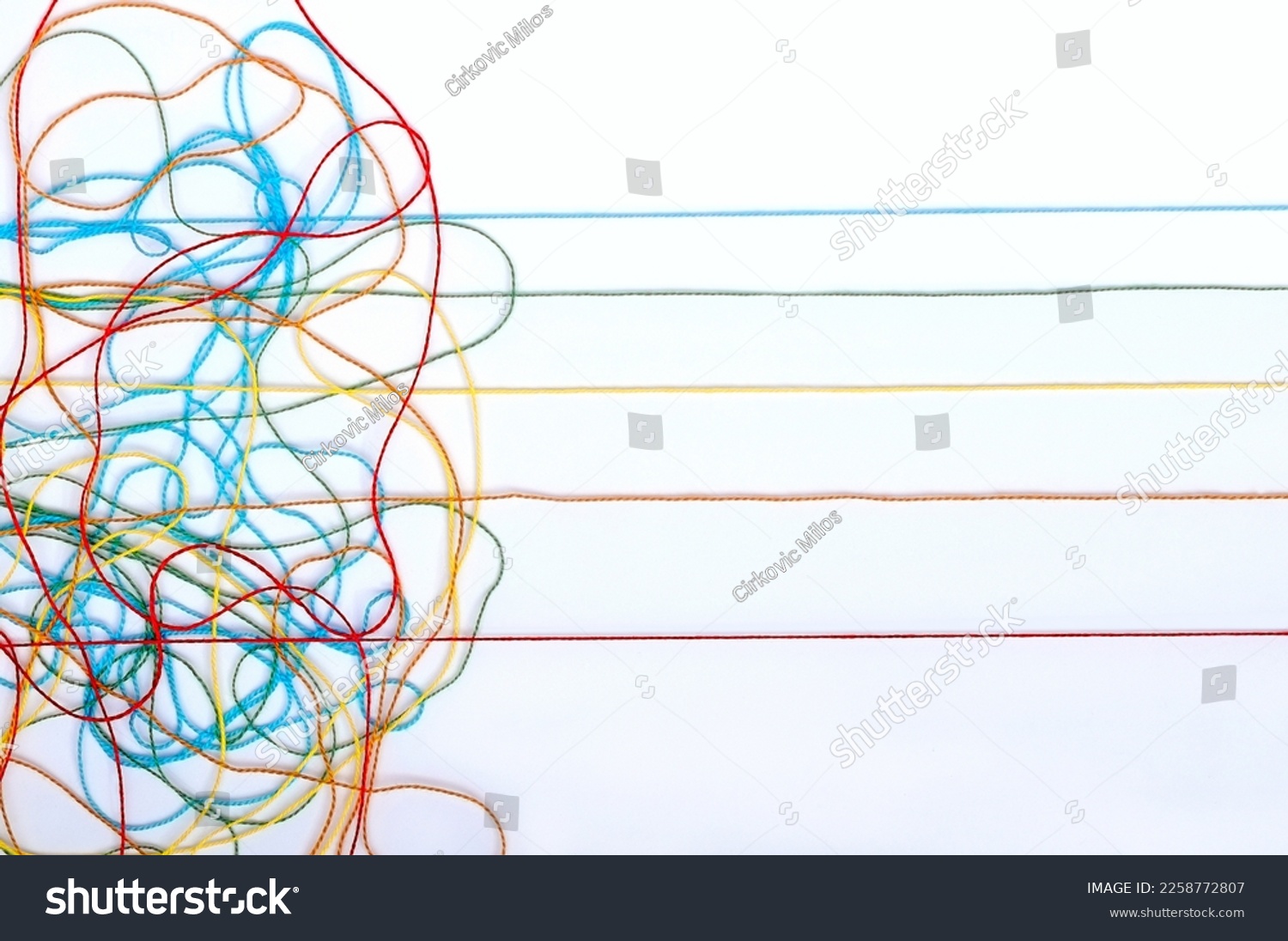 Multicolored tangled knitting threads on a white background #2258772807