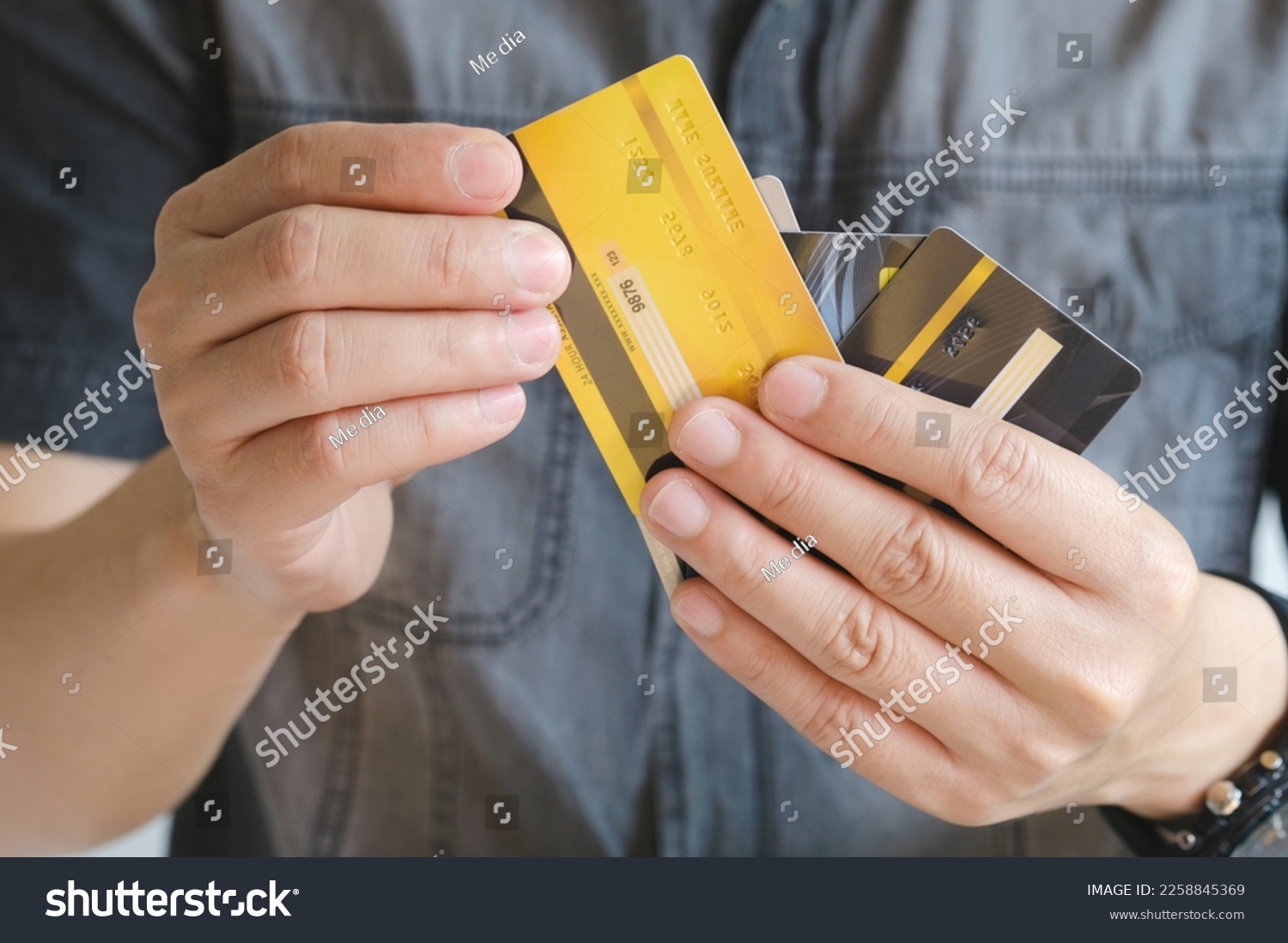 Man holding several credit cards and he is choosing a credit card to pay and spend Payment for goods via credit card. Finance and banking concept. #2258845369