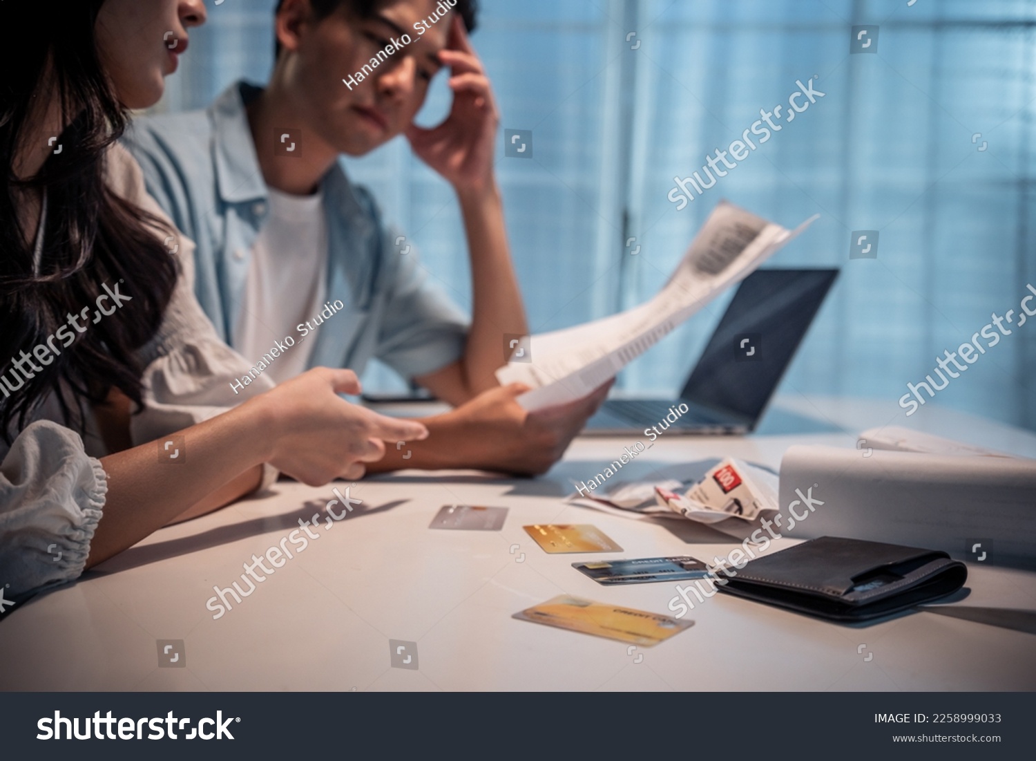 Asian young depressed couple having argument while checking money debt. Attractive new marriage man and woman looking frustrated to paperwork and bill, feel worried about financial problem in house. #2258999033