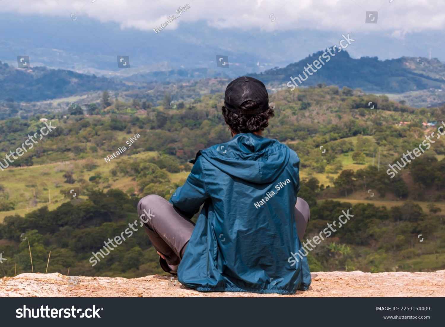 Young man sitting. He is looking at the landscape at sunrise in Guavata, Santander. #2259154409