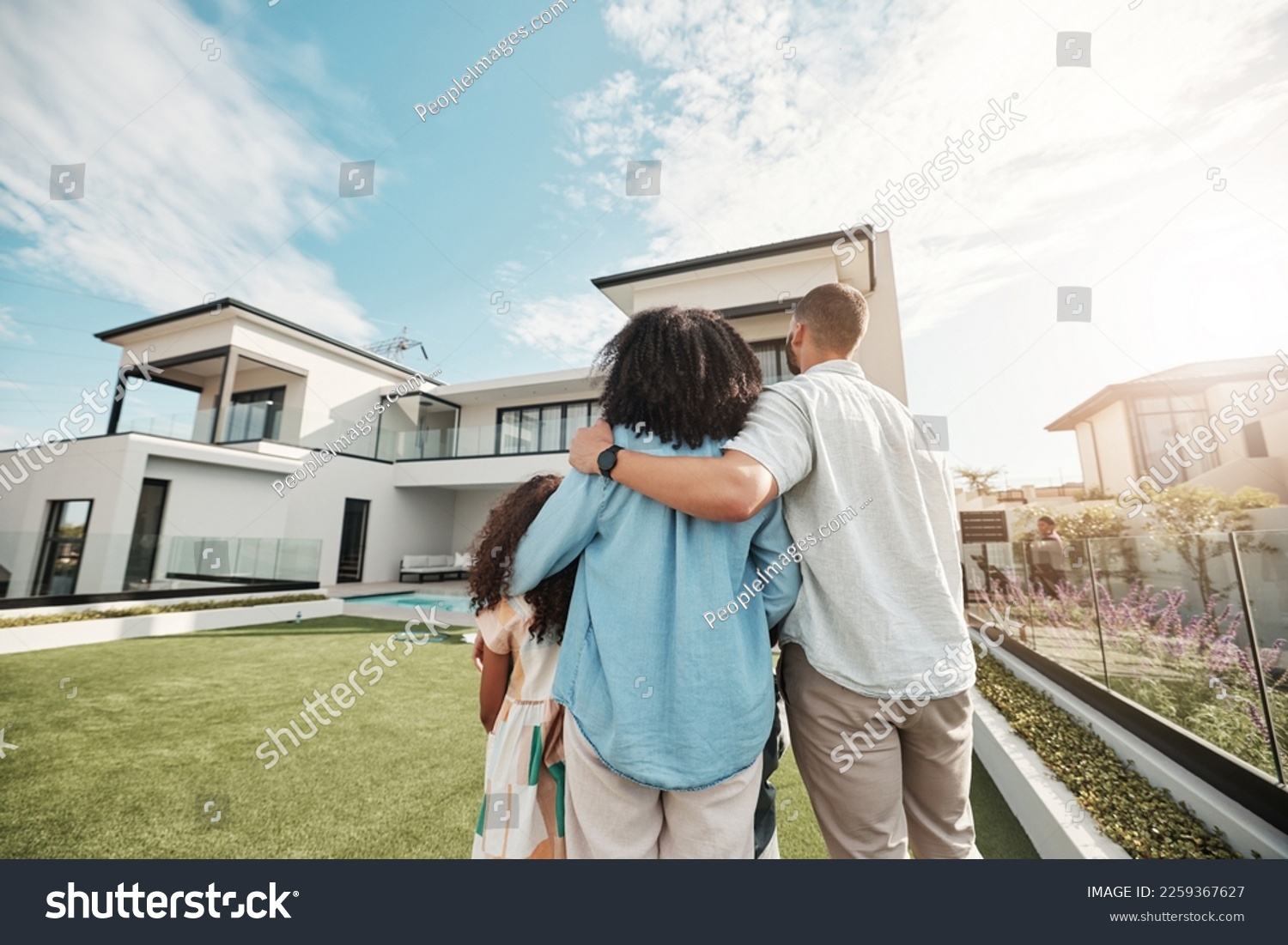 Love, new home and family standing in their backyard looking at their property or luxury real estate. Embrace, mortgage and parents with their children on grass at their house or mansion in Canada. #2259367627