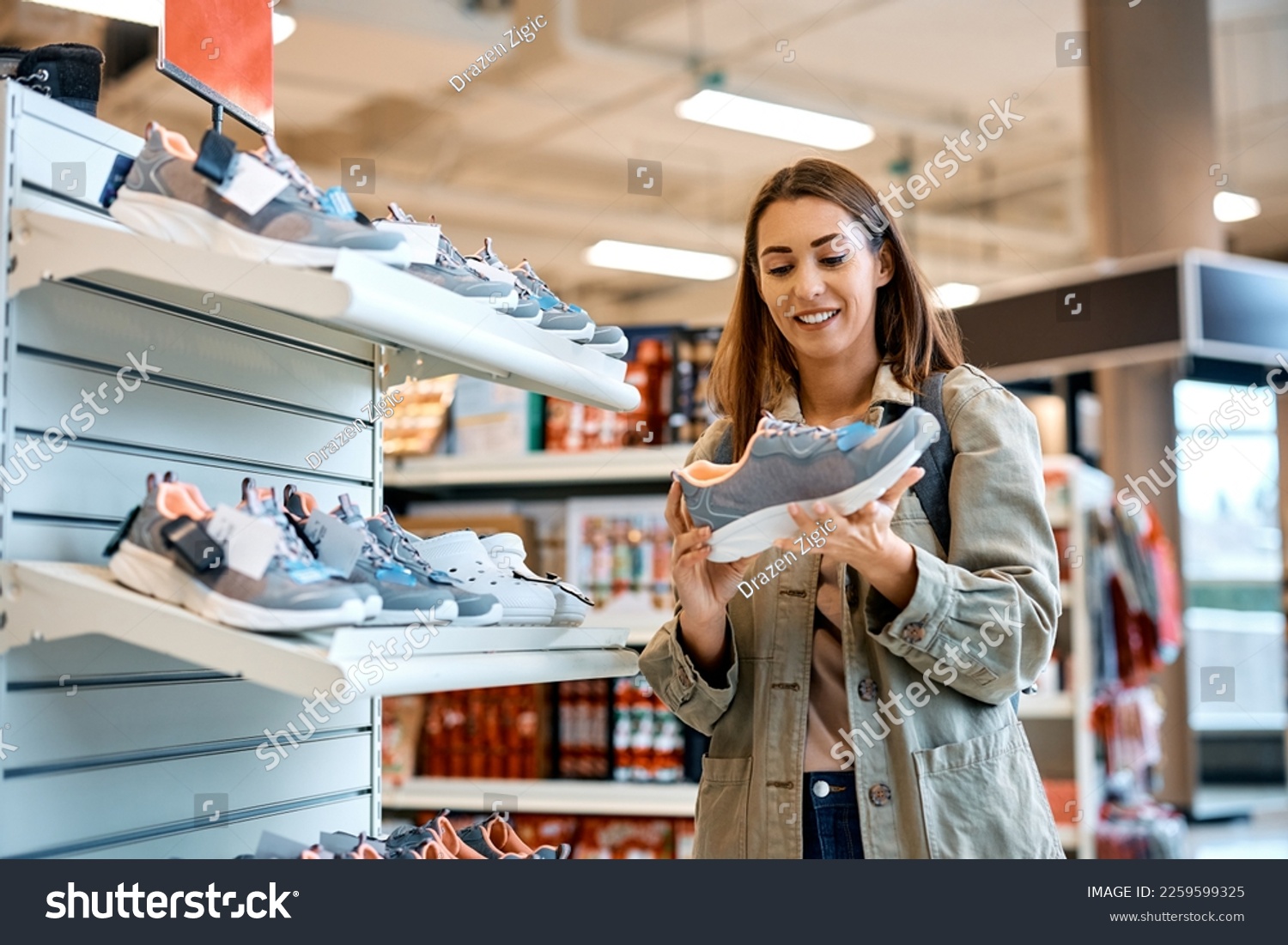 Young happy woman buying sports shoes at shopping mall.  #2259599325