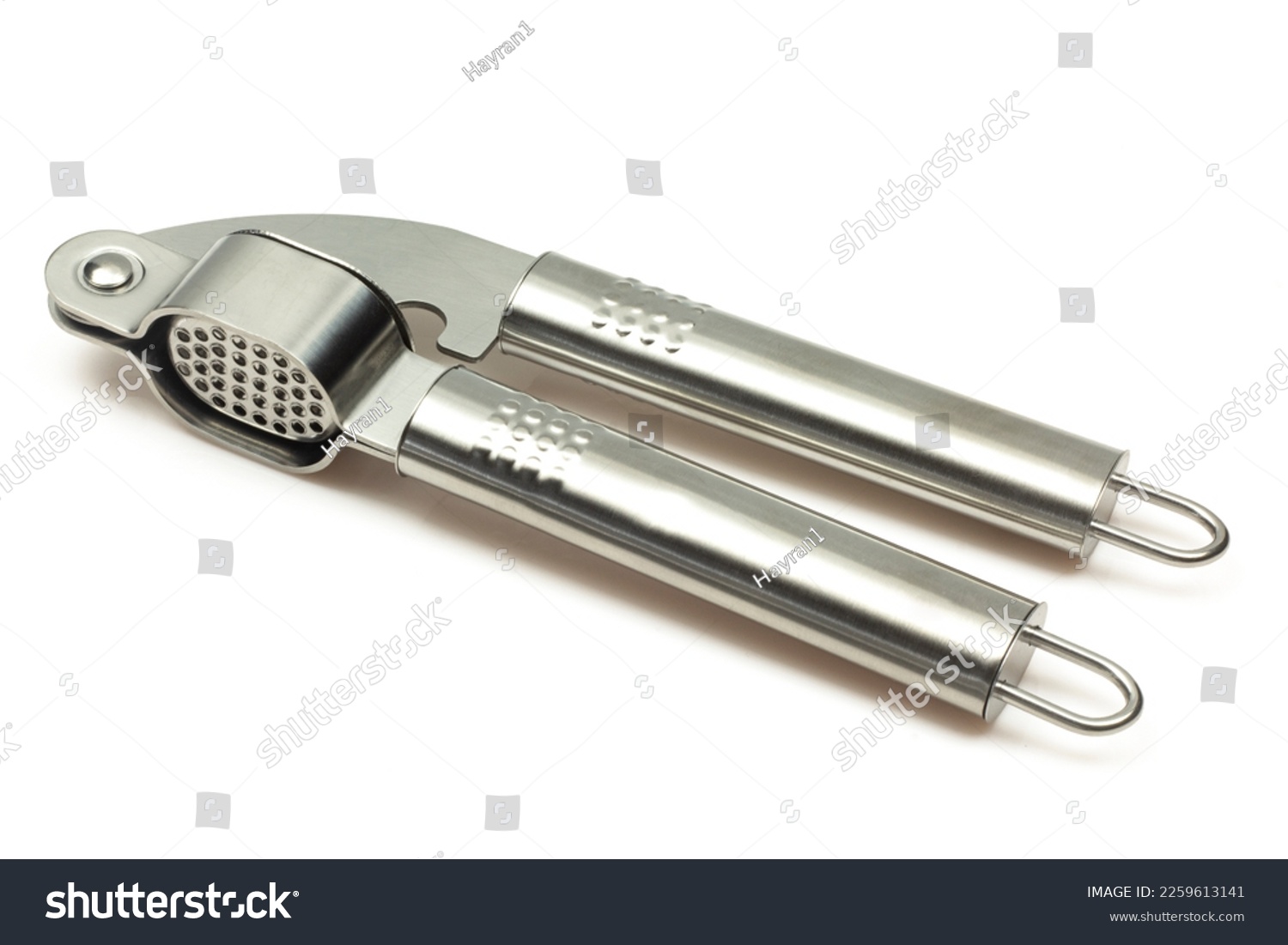 Metallic shiny garlic press crusher tool isolated on white background. Stainless kitchen utensil mincer #2259613141
