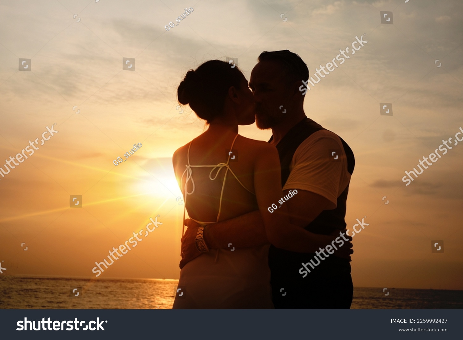 Senior business man and his wife hugging and kissing on celebration event at the yacht deck,Silhouette romance scene marriage anniversary over sunset, luxury and happiness moment #2259992427