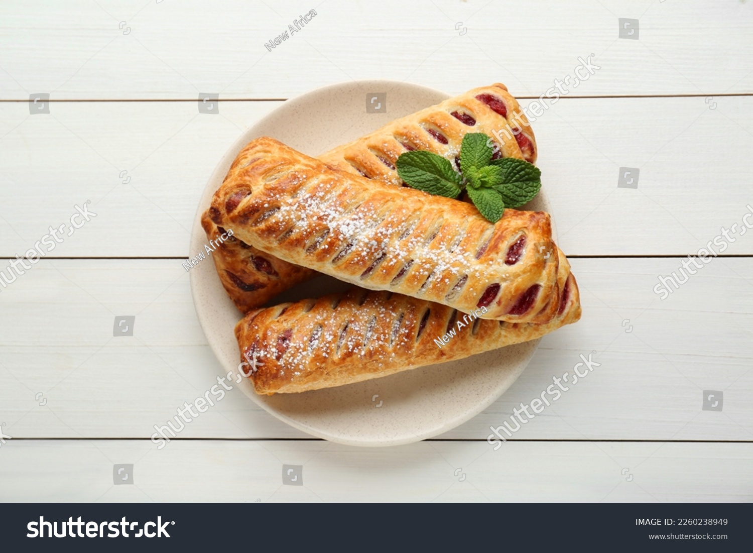 Fresh tasty puff pastry with sugar powder and mint on white wooden table, top view #2260238949