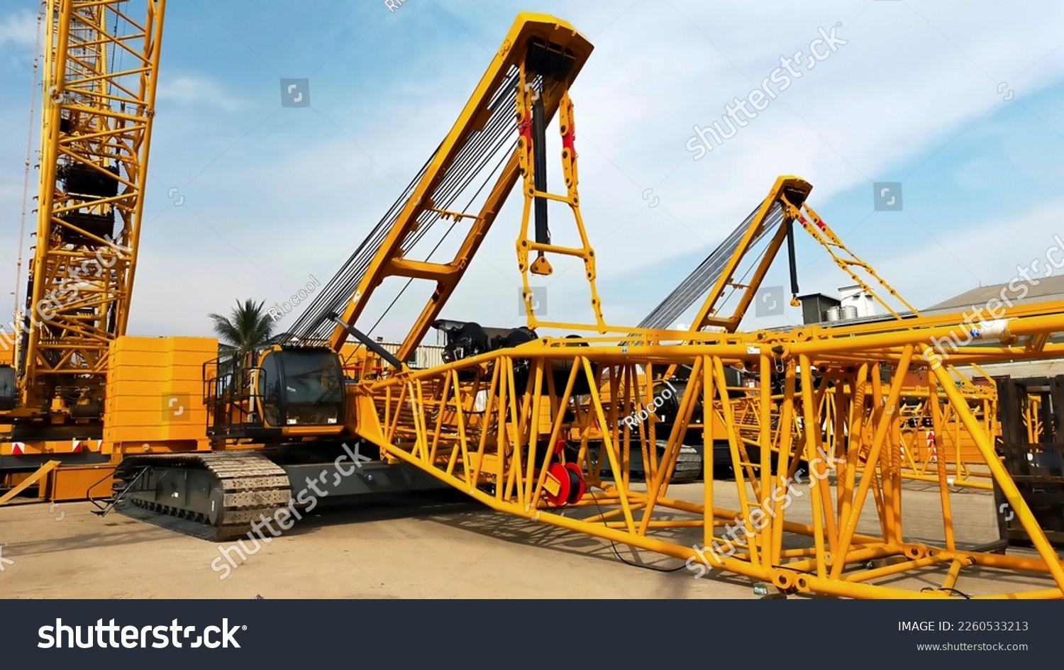 Two big yellow crawler crane assembling the boom and setting up. #2260533213