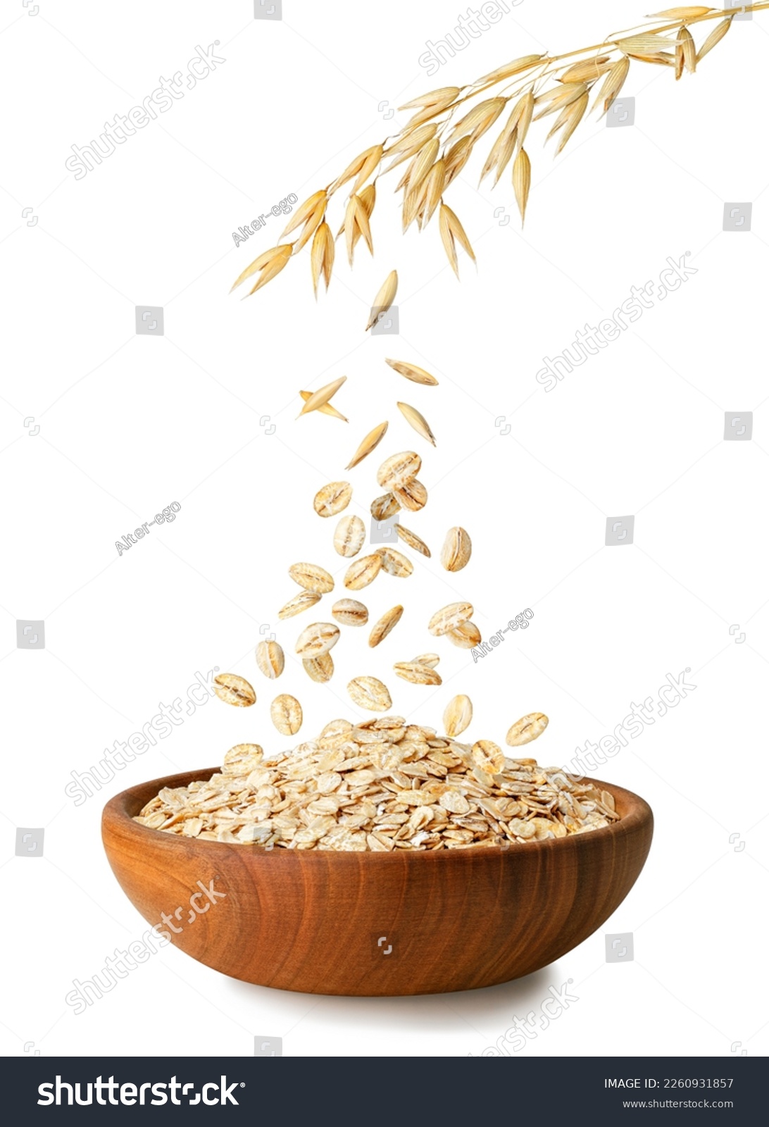 uncooked oatmeal falling from ripe oat ears in wooden bowl isolated on white background #2260931857