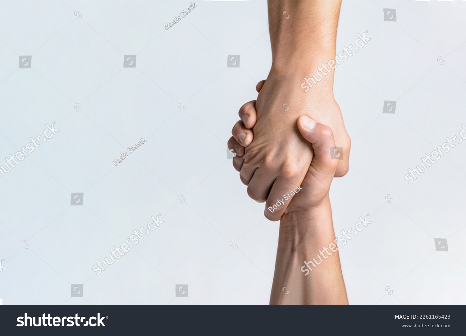 Friendly handshake, friends greeting, teamwork, friendship. Close-up. Rescue, helping gesture or hands. Strong hold. Two hands, helping hand of a friend. Handshake, arms friendship #2261165423