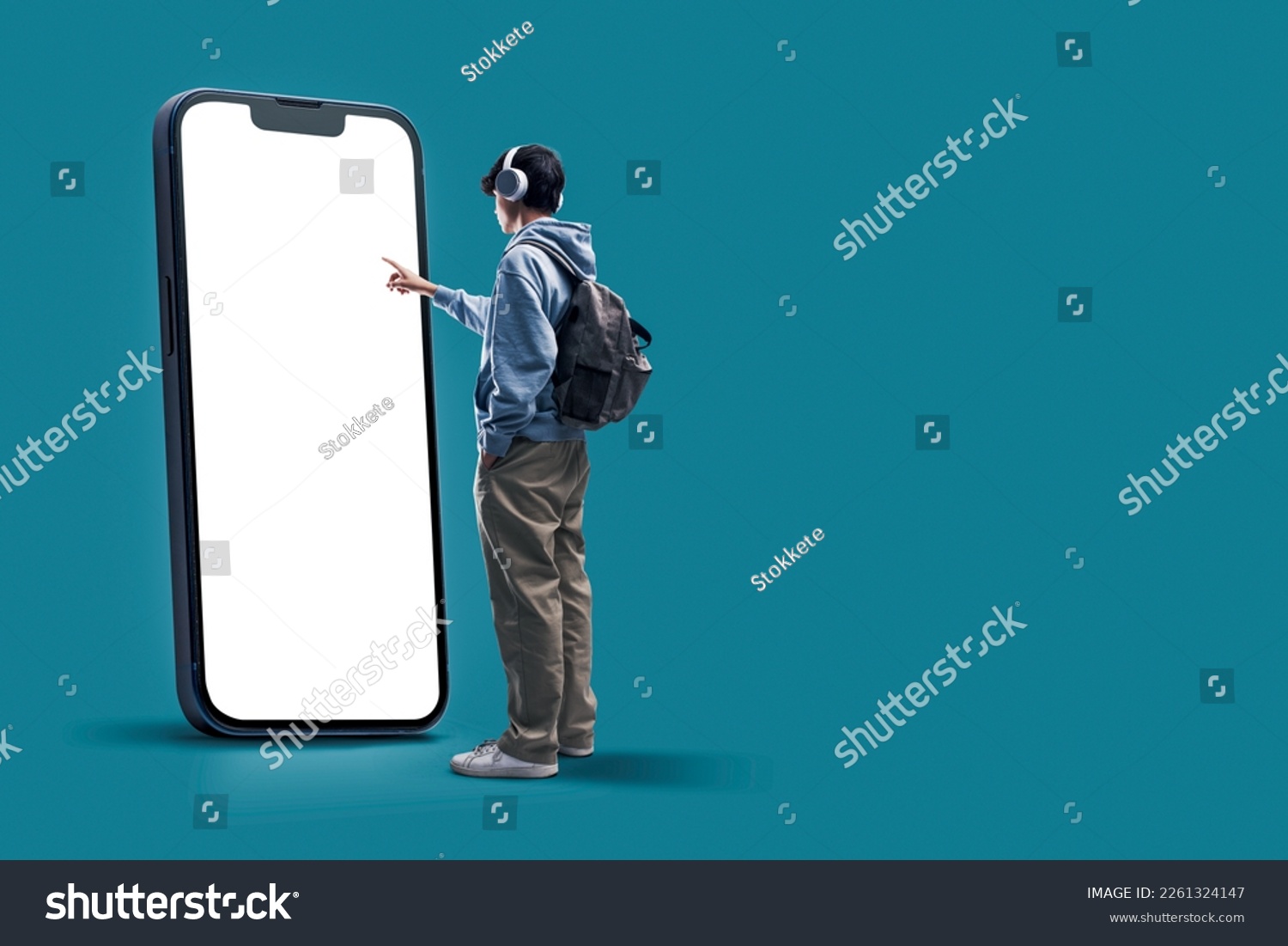 Student interacting with a big touch screen smartphone with blank display, online learning and mobile apps concept, copy space #2261324147