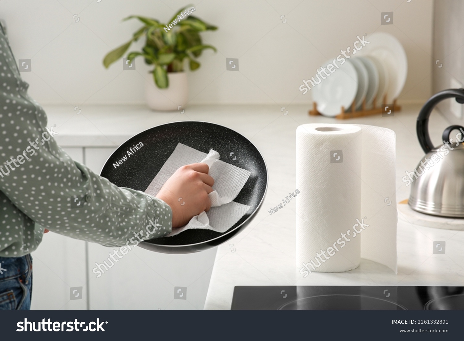 Woman wiping frying pan with paper towel in kitchen, closeup #2261332891