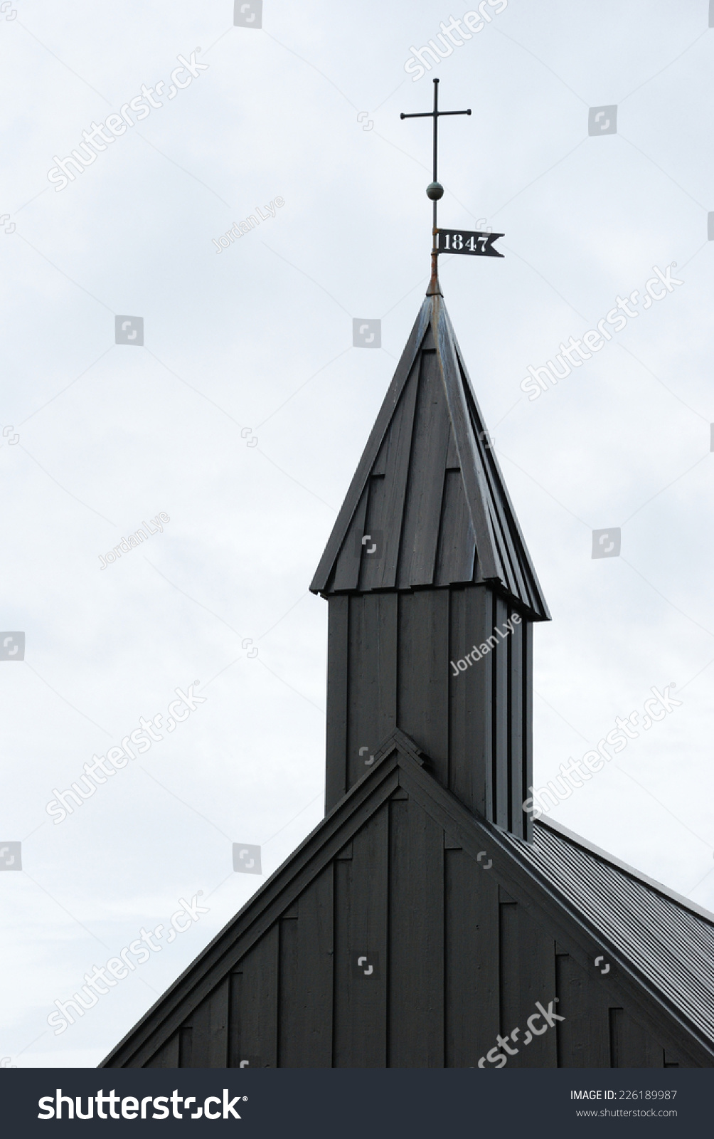 close up Detailed view of black wooden church in front of a mountain chain in Budir, Iceland  #226189987