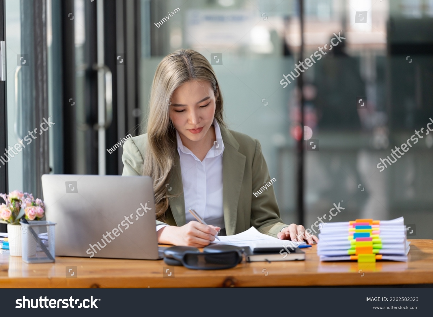 Businesswoman working at the workplace. beautiful Asian woman in a casual suit working reading a book, preparing for a meeting or interview in the office. #2262582323