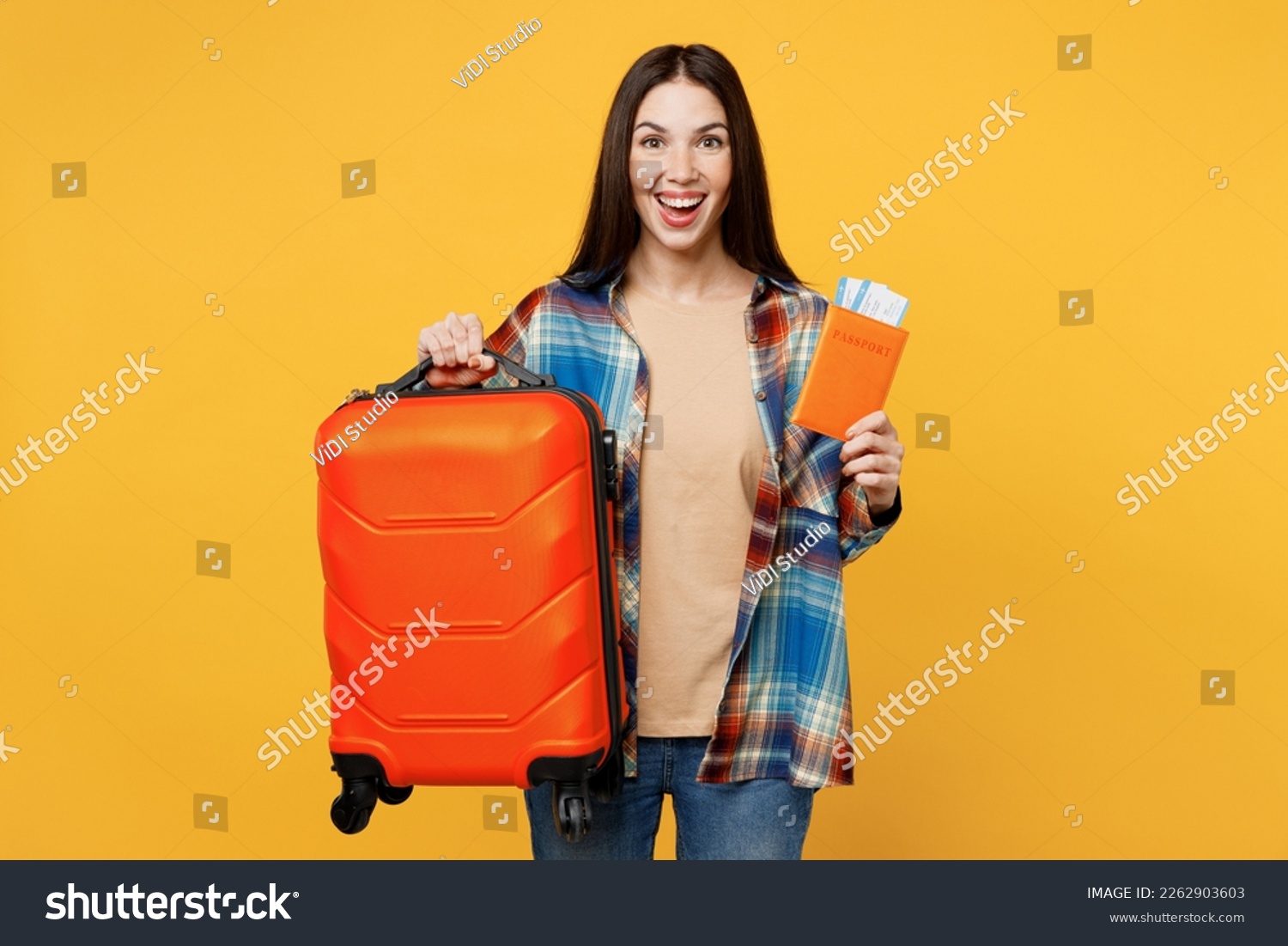 Traveler happy woman wear casual clothes hold valise passport ticket isolated on plain yellow background studio. Tourist travel abroad in free spare time rest getaway. Air flight trip journey concept #2262903603
