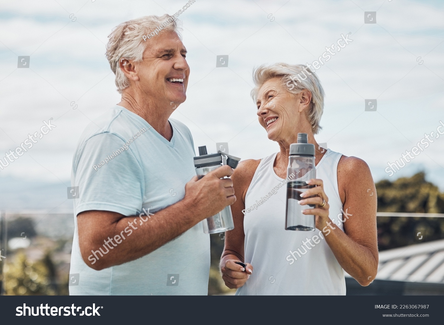 Senior couple, fitness and water bottle with smile for hydration or thirst after workout, exercise or training in nature. Happy elderly man and woman smiling for natural refreshment from exercising #2263067987