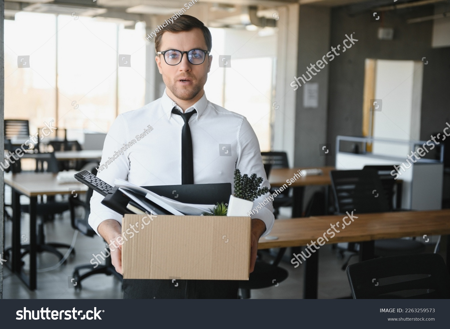 Sad Fired. Let Go Office Worker Packs His Belongings into Cardboard Box and Leaves Office. Workforce Reduction, Downsizing, Reorganization, Restructuring, Outsourcing. Mass Unemployment Market Crisis. #2263259573