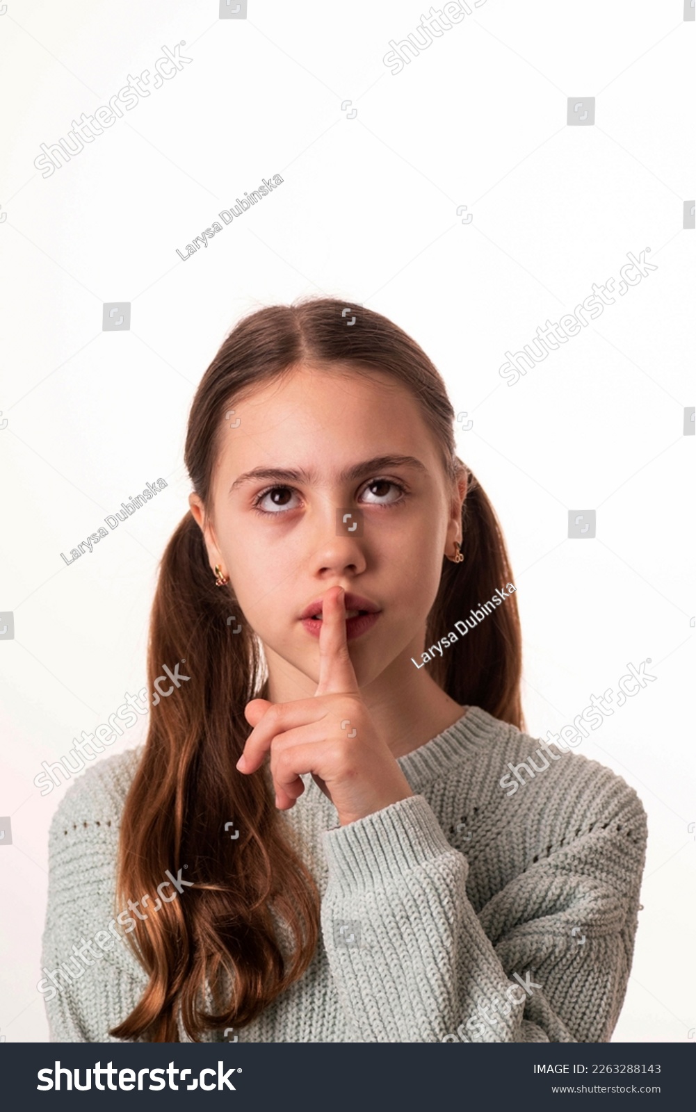 10-year-old girl, looking up, put finger to her - Royalty Free Stock ...