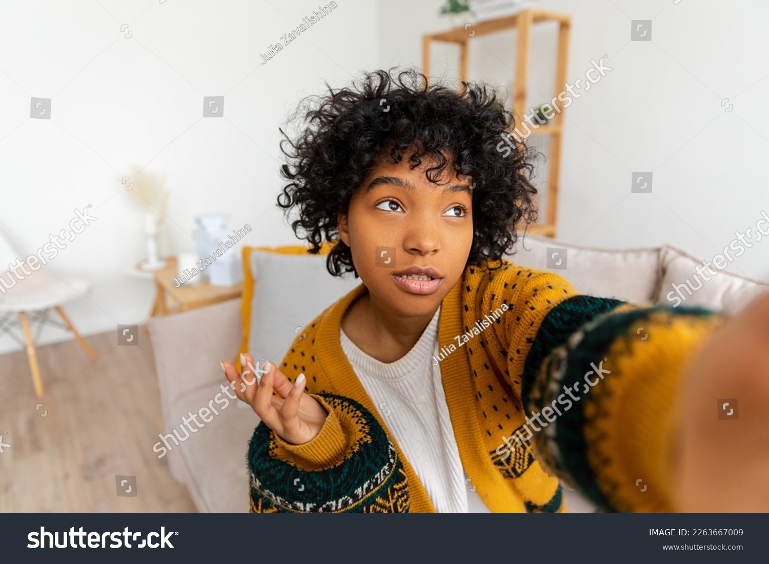 Happy african american teen girl blogger smiling face talking to webcam recording vlog. Social media influencer woman streaming making video call at home. Headshot portrait selfie webcamera view #2263667009